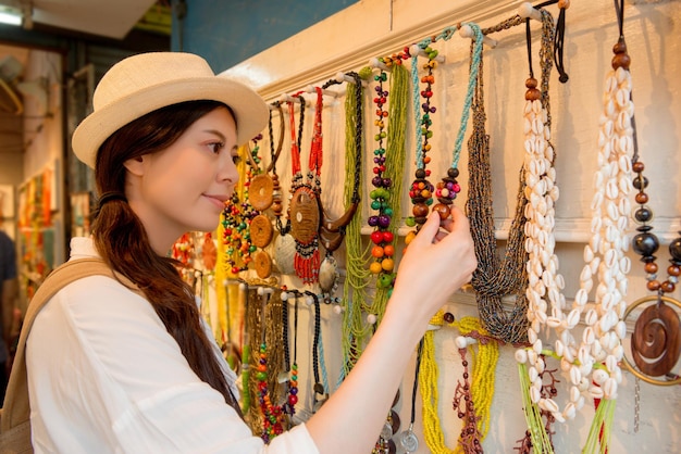 Photo une femme chinoise asiatique de race mixte voyage dans la ville de hong kong à la recherche d'un joli collier de bijoux traditionnel achetant pour la famille comme cadeau de vacances chez des vendeurs célèbres locaux.