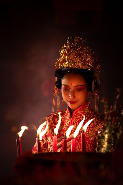 Une femme chinoise fait des vœux, prie et allume des bougies à l'occasion du Nouvel An chinois annuel.