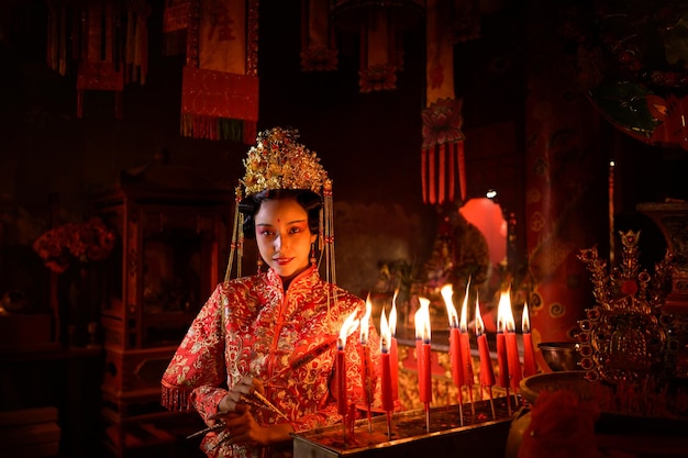 Une femme chinoise fait des vœux, prie et allume des bougies à l'occasion du Nouvel An chinois annuel.