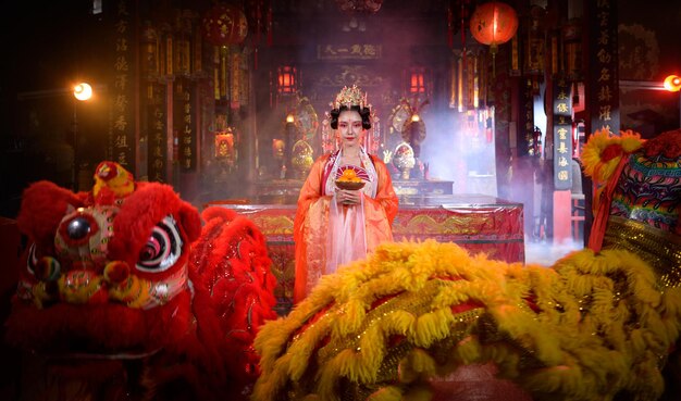 Une femme chinoise avec des lions jaunes et rouges est considérée comme améliorant la prospérité pour soi-même.