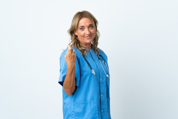 Femme chirurgien d'âge moyen sur isolé avec les doigts qui se croisent et souhaitant le meilleur