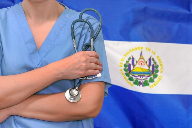 Femme chirurgien ou médecin avec stéthoscope sur le fond du drapeau d'El Salvador