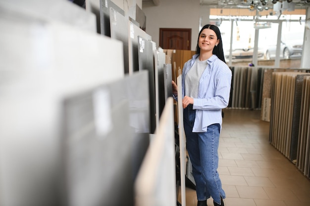 Une femme choisissant des carreaux de salle de bain sur le marché du bâtiment