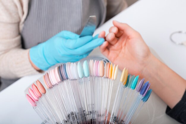 Femme choisissant la couleur parfaite pour ses ongles au salon