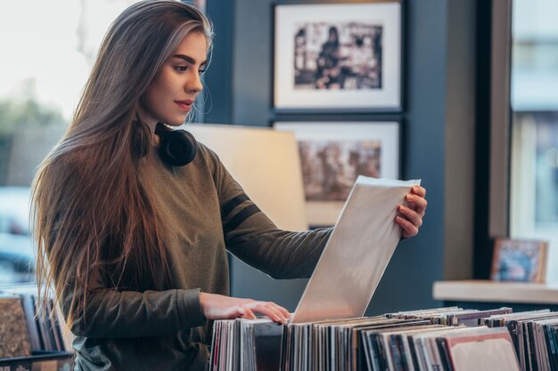 Femme choisissant un disque vinyle dans un magasin de disques