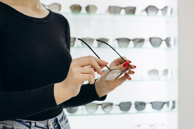 Femme choisissant une paire de lunettes au magasin d'optique