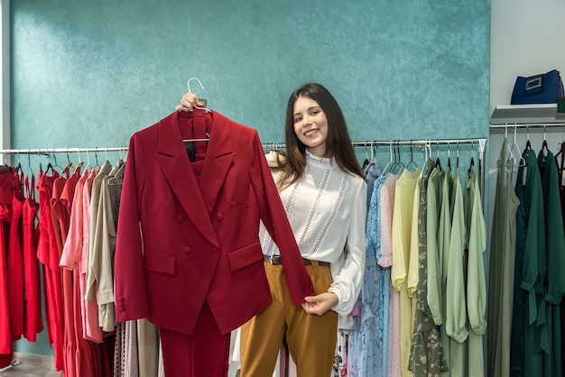 Femme choisissant une veste ou une robe élégante dans un magasin de vêtements