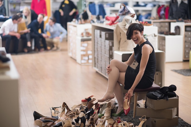 Femme choisit des chaussures à la boutique à la mode