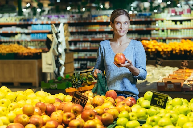 Femme choisit choisit des fruits légumes sur le comptoir du supermarché femme au foyer shopping dans