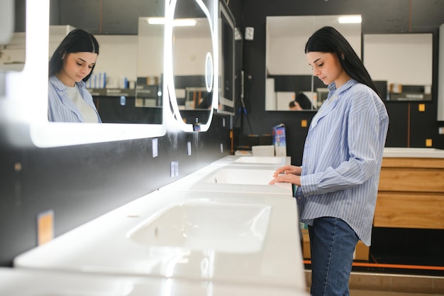 Une femme choisit un miroir à la maison dans un magasin