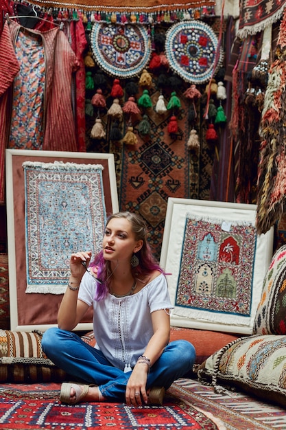 La femme choisit le tapis au marché.