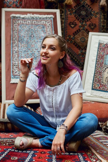 Une femme choisit un tapis au marché