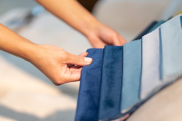 La femme choisit le tissu sur le canapé