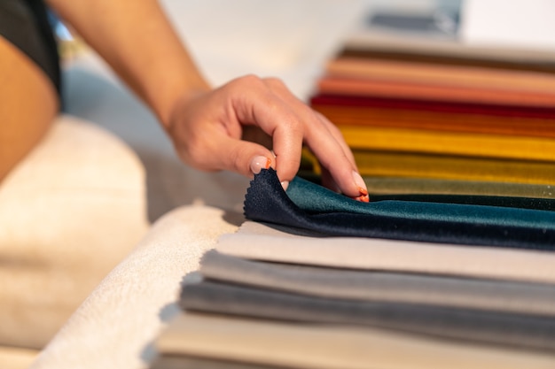 Photo la femme choisit le tissu sur le canapé