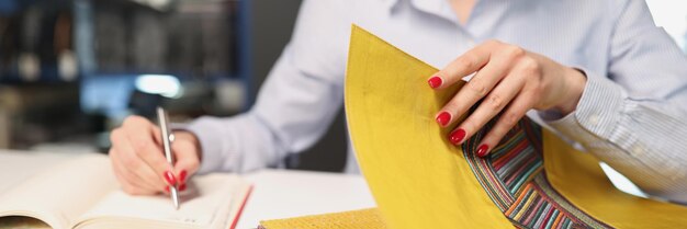 Photo la femme choisit le tissu avec le motif pour la tapisserie d'ameublement à l'intérieur du concept de catalogue de tissu de magasin