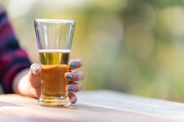 Une femme avec une chope de bière sur la table