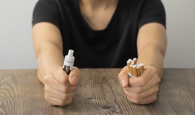 Femme avec cigare et vaper dans les mains avec les poings serrés