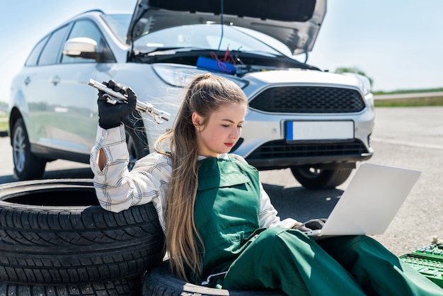 Femme, à, clés, et, ordinateur portable, entretien, voiture cassée