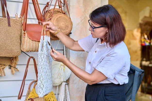 Femme cliente achetant un sac écologique tissé à la mode dans le magasin