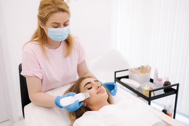 Une femme à la clinique de spa de beauté cosmétique a une cosmétologie du matériel facial