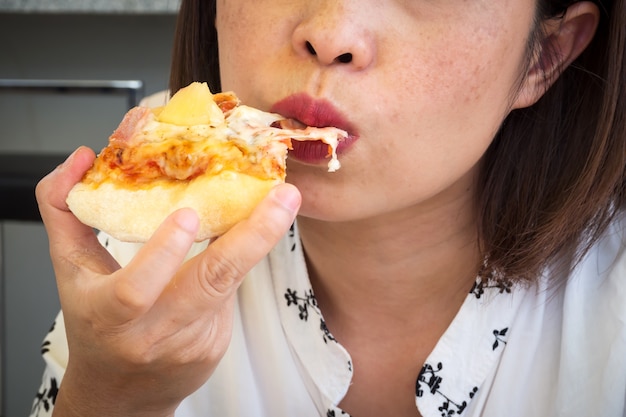 Femme CloseUp, manger de la pizza. Gros plan sur le visage et la bouche.