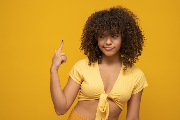 Femme avec coiffure afro et haut jaune