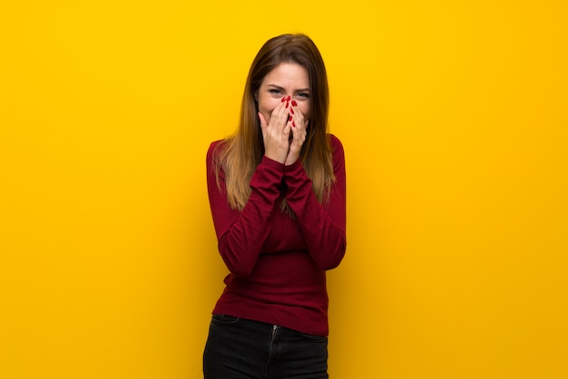 Femme, à, col roulé, sur, jaune, mur, sourire