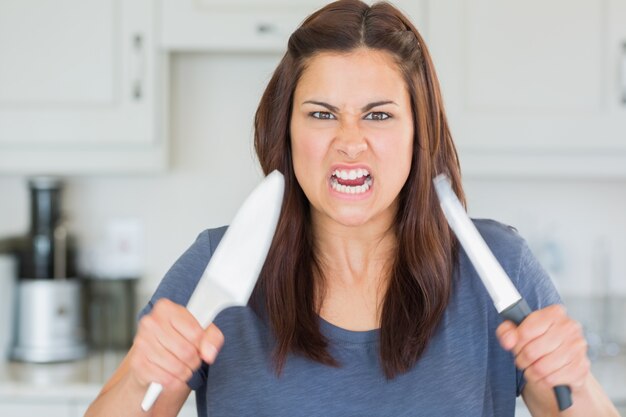 Femme en colère brandissant des couteaux
