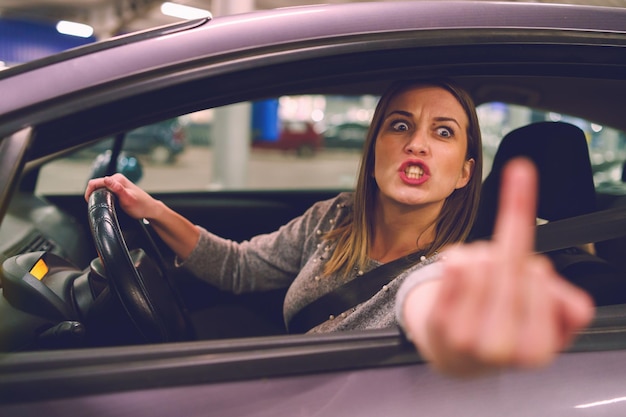 Photo une femme en colère faisant un geste obscène assise dans la voiture.