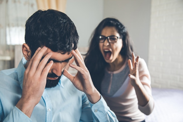 Femme en colère avec un homme triste à la maison