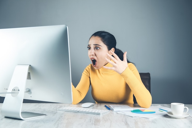 Femme en colère avec ordinateur au bureau