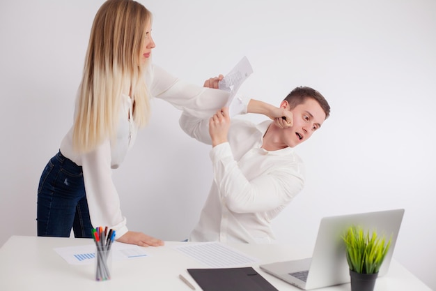 Une femme en colère se bagarre avec le directeur au bureau de l'entreprise.