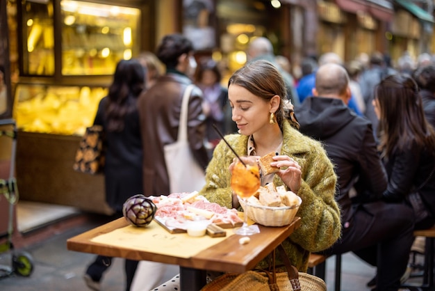 Femme avec des collations italiennes et des boissons au bar à l'extérieur