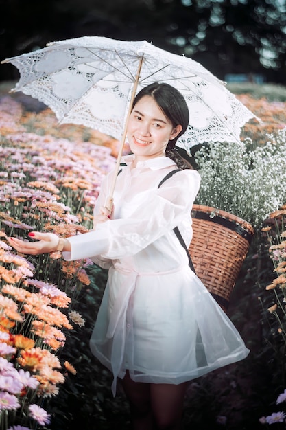 Femme, collecte, fleurs, tenue, parapluie