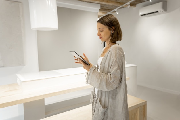 La femme communique par une tablette numérique à la maison