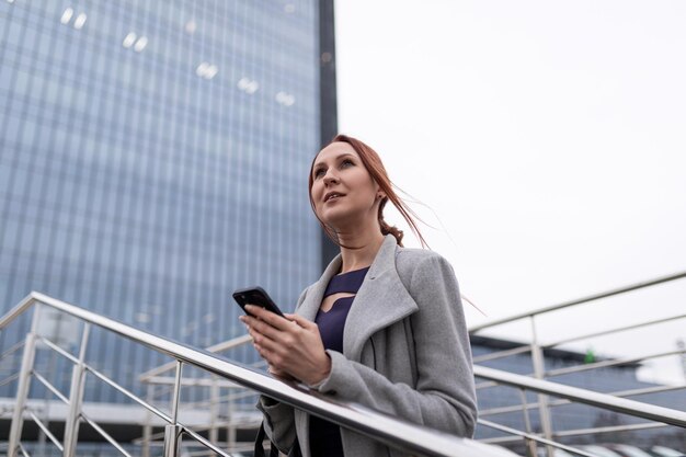 Femme comptable avec un téléphone portable dans les mains au bureau