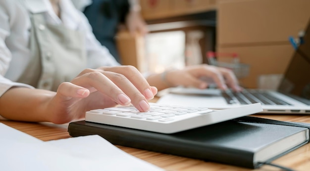 Femme comptable travaillant au bureau à l'aide d'une calculatrice pour calculer le rapport financier. Image recadrée, vue rapprochée.