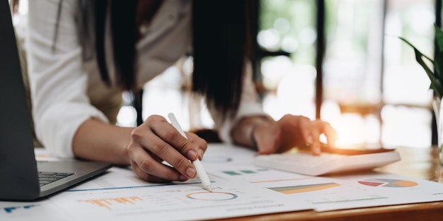 Femme comptable travaillant avec de la paperasse et une calculatrice pour les dépenses commerciales et financières