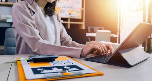 Femme comptable utiliser la calculatrice et l'ordinateur avec un stylo sur