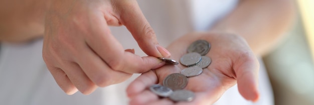 Femme comptant des pièces dans ses mains en gros plan économiser de l'argent concept de pauvreté et d'économie