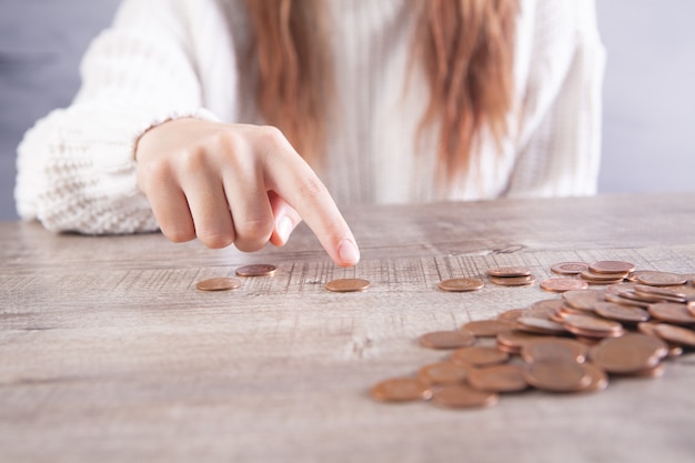 Femme comptant des pièces sur la table