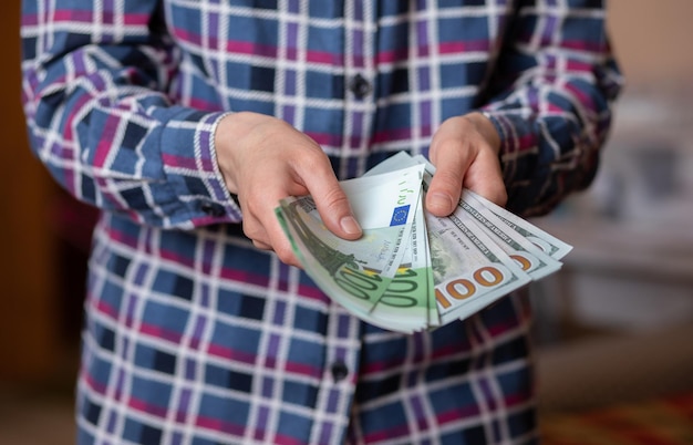 Une femme compte de l'argent des mains féminines détiennent des coupures de billets en espèces de 100 euros 100 dollars