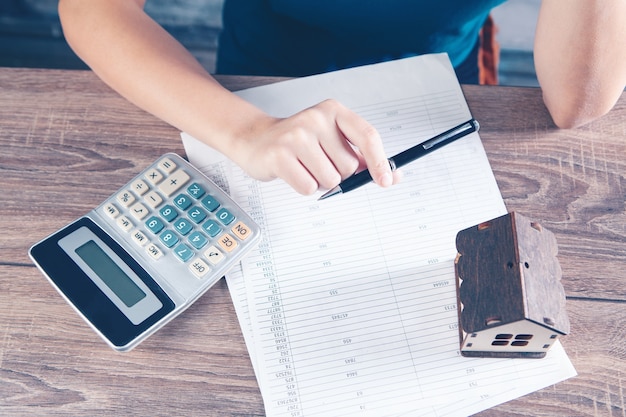 La Femme Compte Sur Une Calculatrice Devant La Maison