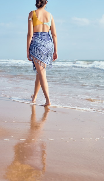 Femme avec compteur de diabète marchant sur la plage