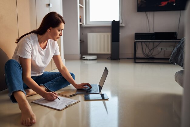 Femme concentrée étudiant en ligne à la maison