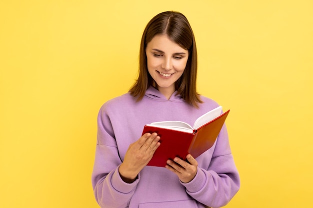 Femme concentrée lisant un livre intéressant étant très attentive avec une intrigue intéressante