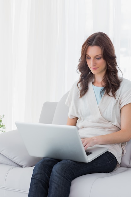 Femme concentrée avec un ordinateur portable sur ses genoux