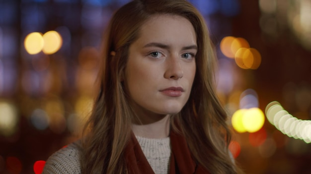 Femme concentrée posant la caméra à l'extérieur Dame sérieuse regardant la caméra dans la rue