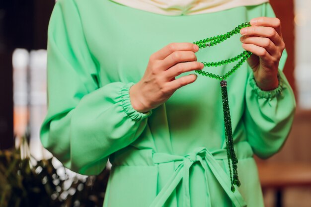 Femme concentrée priant portant des perles de chapelet. Namaste. Gros plan des mains.