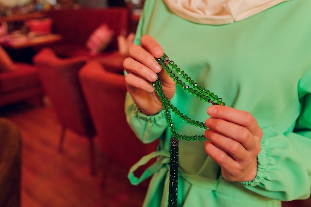 Femme concentrée priant portant des perles de chapelet. Namaste. Gros plan des mains.